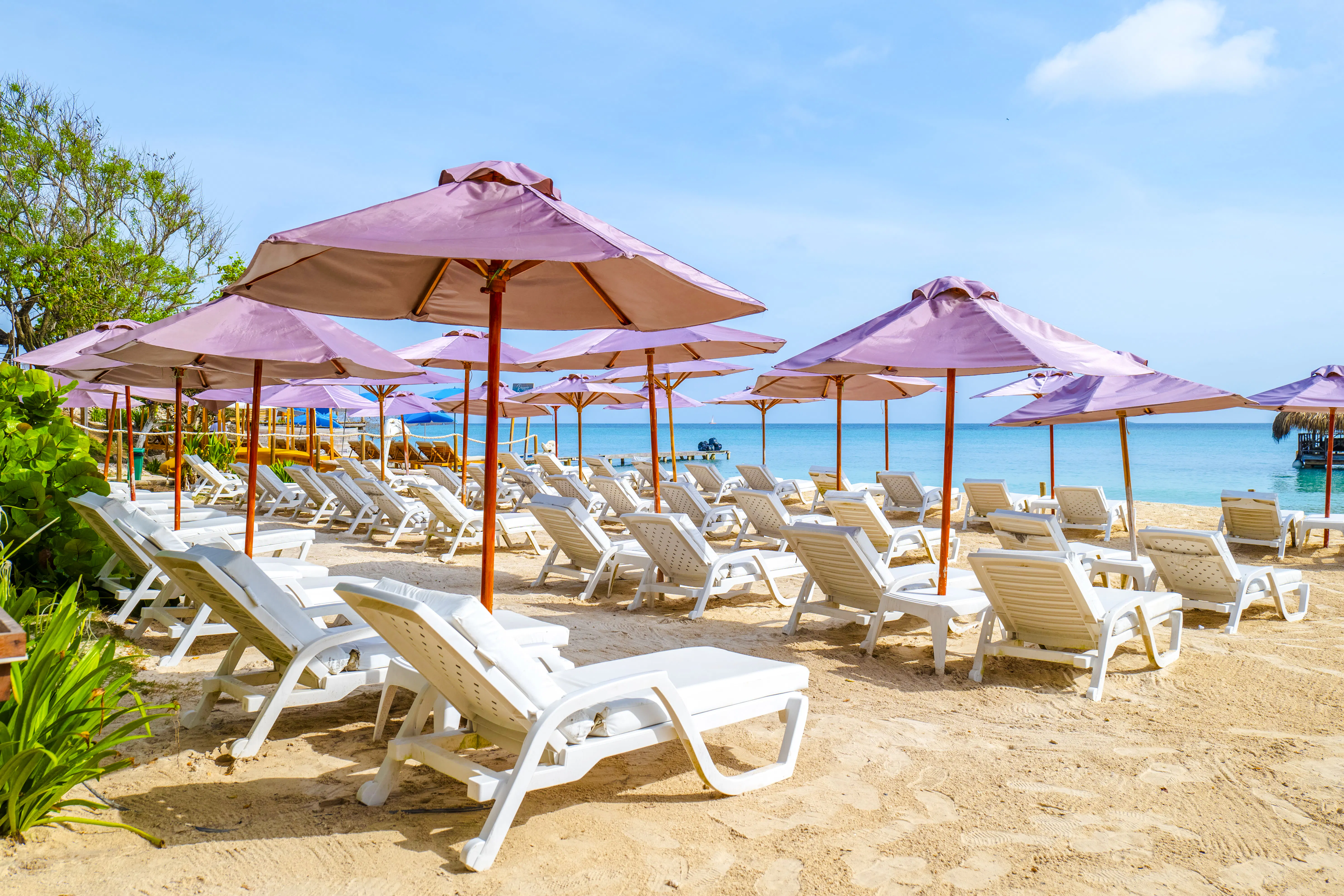 Sun loungers and umbrellas on a sandy beach in Rosario Islands, Cartagena.