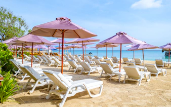 Sun loungers and umbrellas on a sandy beach in Rosario Islands, Cartagena.