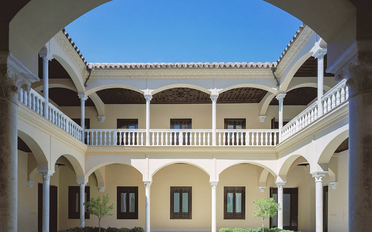 Courtyard of the Picasso Museum in Malaga with arches and columns.