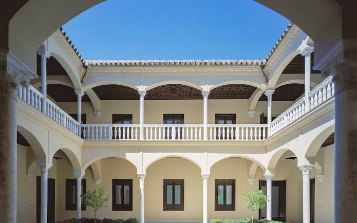 Courtyard of the Picasso Museum in Malaga with arches and columns.