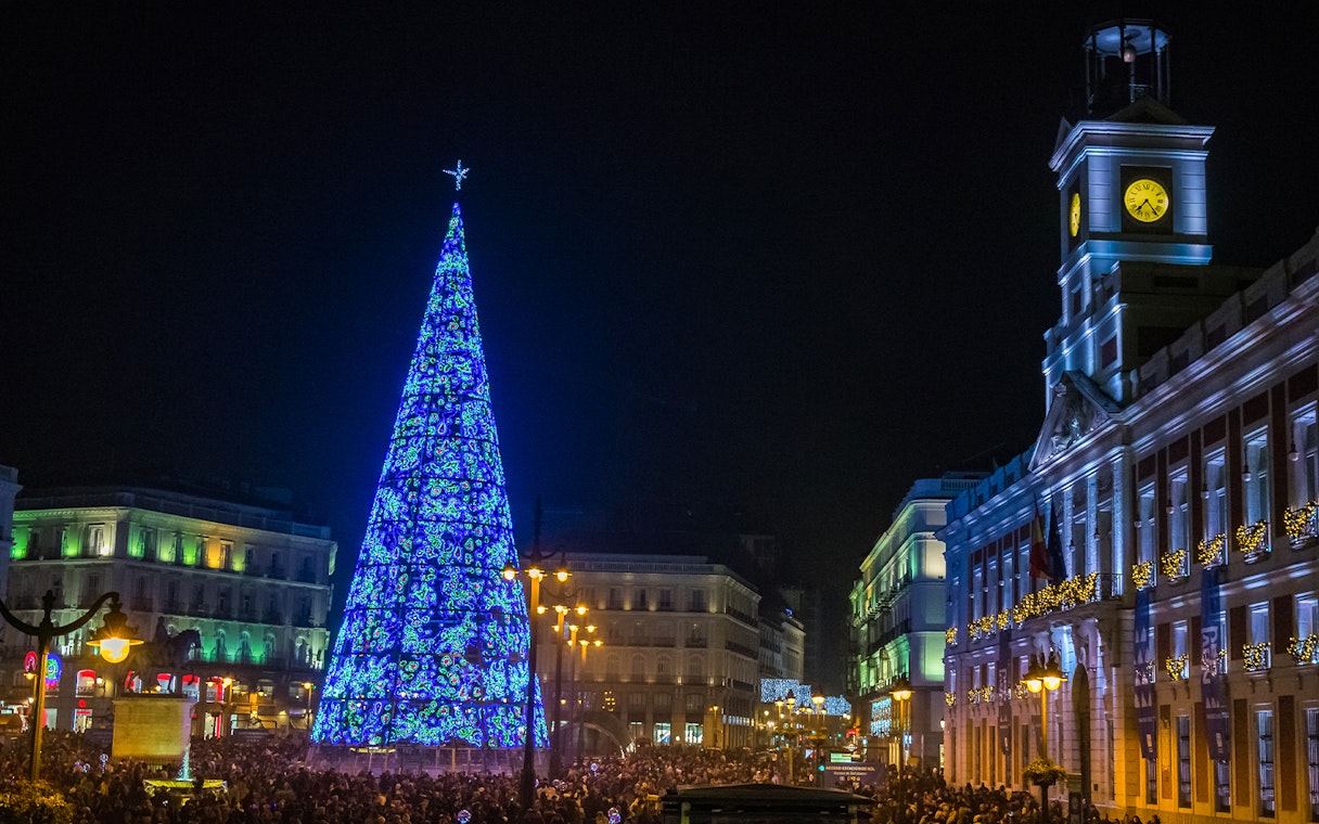 Puerta del Sol Clock Tower and illuminated Christmas tree at night, Madrid, Spain.