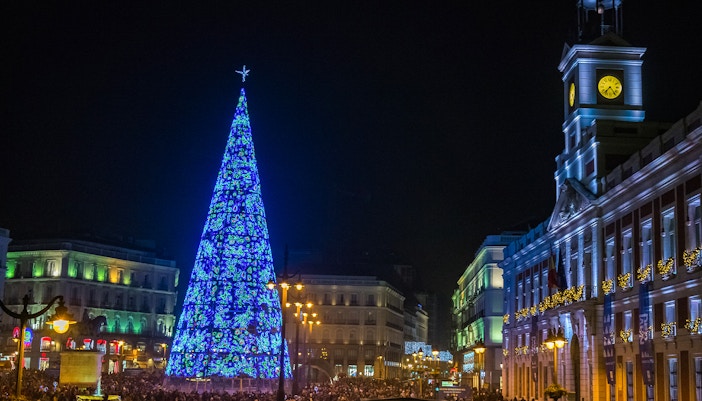 Puerta del Sol Clock Tower and illuminated Christmas tree at night, Madrid, Spain.