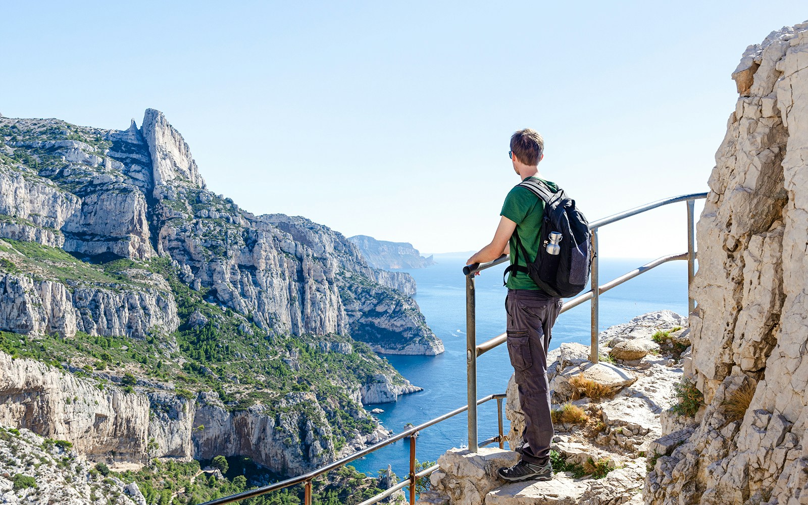 Hiker overlooking cliffs and sea at Calanques National Park, Marseille.