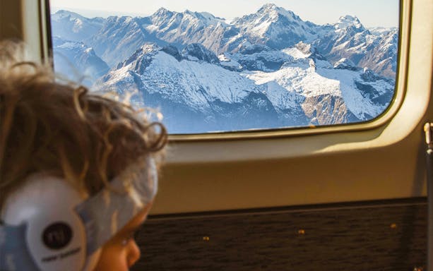 View of snow-capped mountains from airplane window on Milford Sound flyover tour.