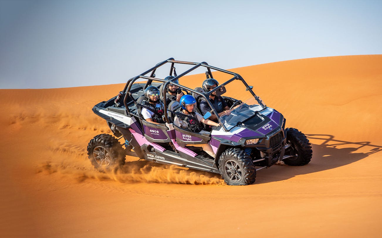Dune buggy driving through sand dunes on a self-drive tour in Mleiha.