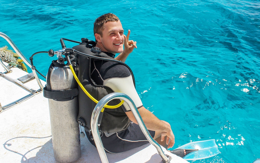 Scuba diver preparing to enter the water in Tanjung Benoa, Bali.