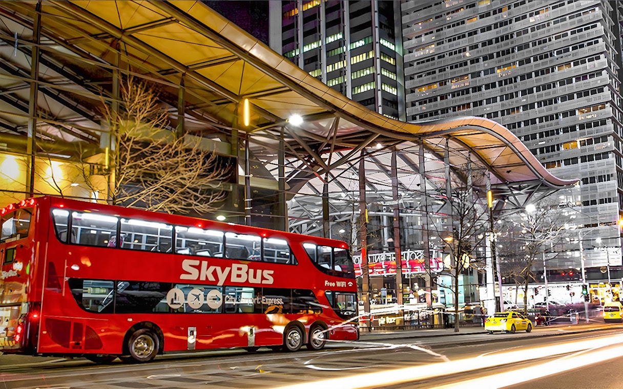 Skybus Melbourne Airport Shuttle at night in city center.