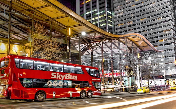 Skybus Melbourne Airport Shuttle at night in city center.
