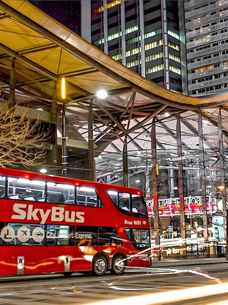 Skybus Melbourne Airport Shuttle at night in city center.