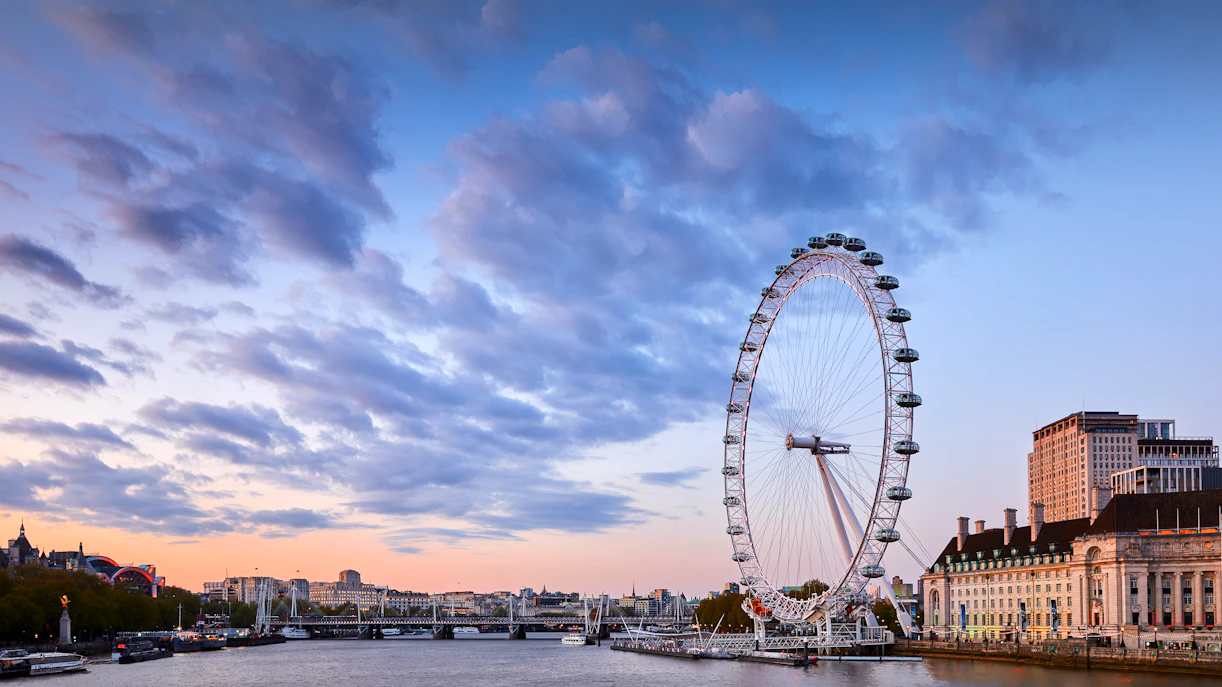 London Eye overlooking the Thames River at sunset.