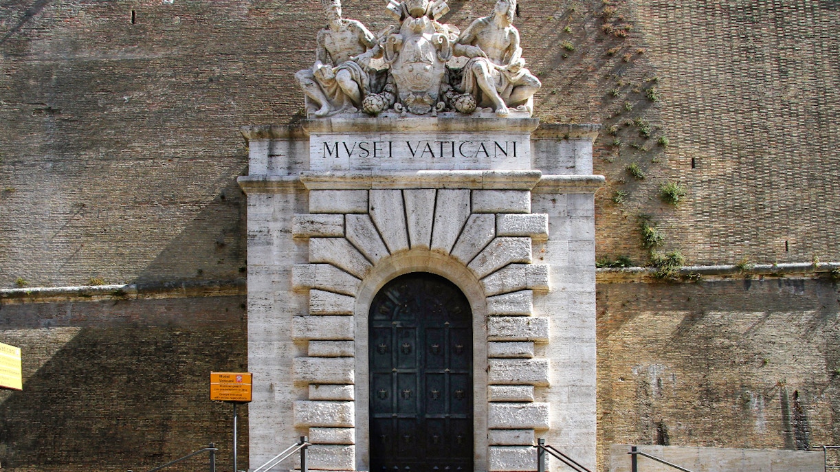 Entrance to the Vatican Museums with sculptures above the door in Rome.