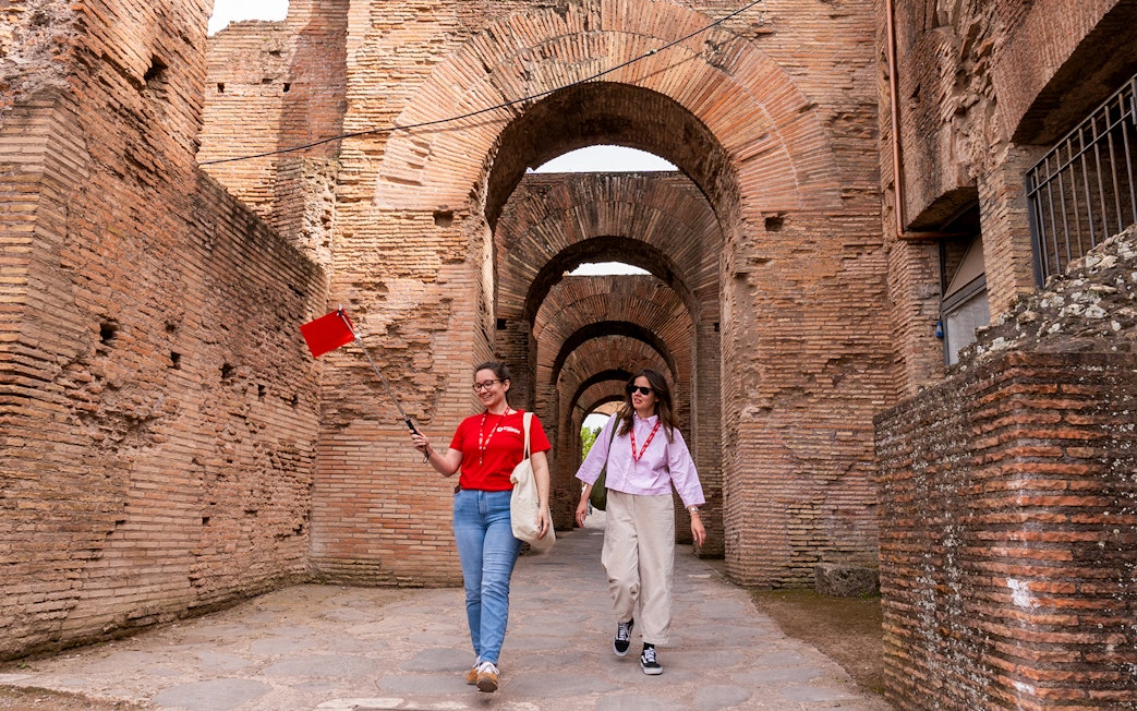 Tour guide leading visitors through Colosseum underground passage in Rome.