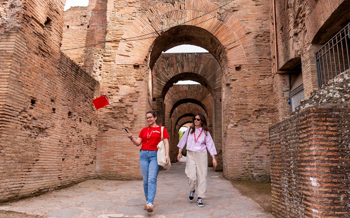 Tour guide leading visitors through Colosseum underground passage in Rome.