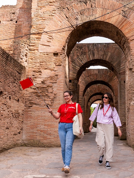 Tour guide leading visitors through Colosseum underground passage in Rome.
