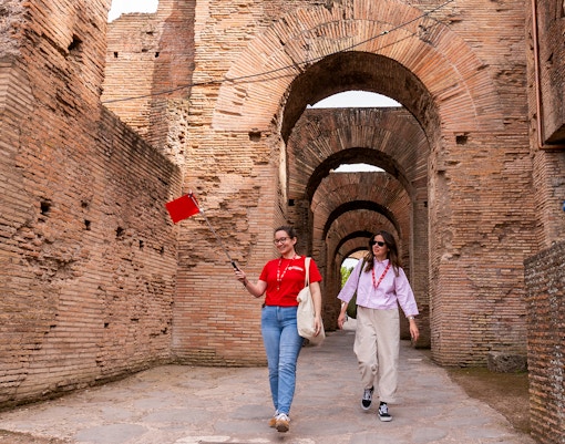 Tour guide leading visitors through Colosseum underground passage in Rome.