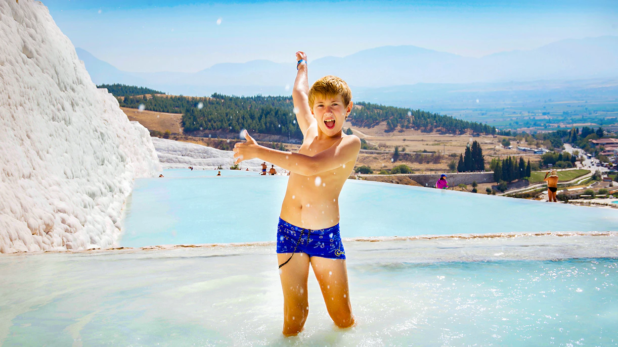 Child enjoying thermal pools at Pamukkale, with travertine terraces and scenic views in Antalya.