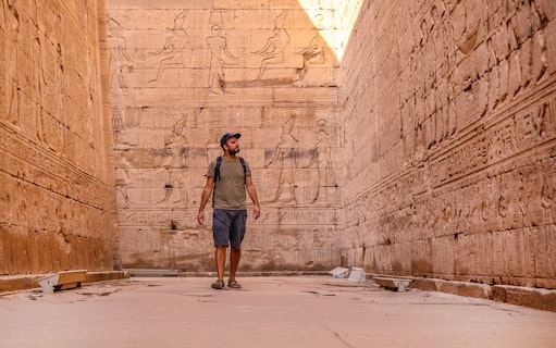 Man admiring Egyptian relief sculptures at Temple of Horus, Edfu.