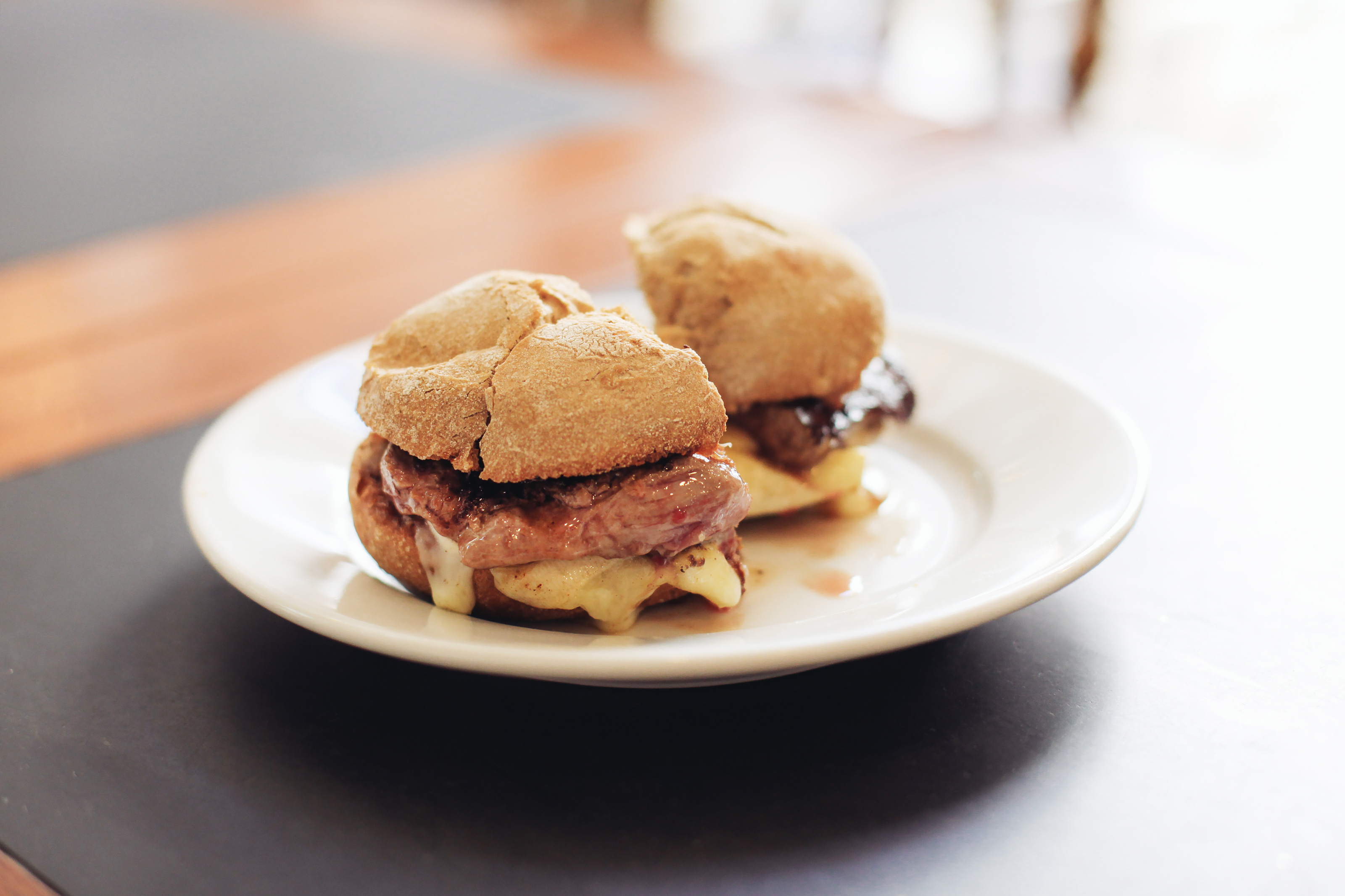 Prego sandwich with steak and mountain cheese on a plate.