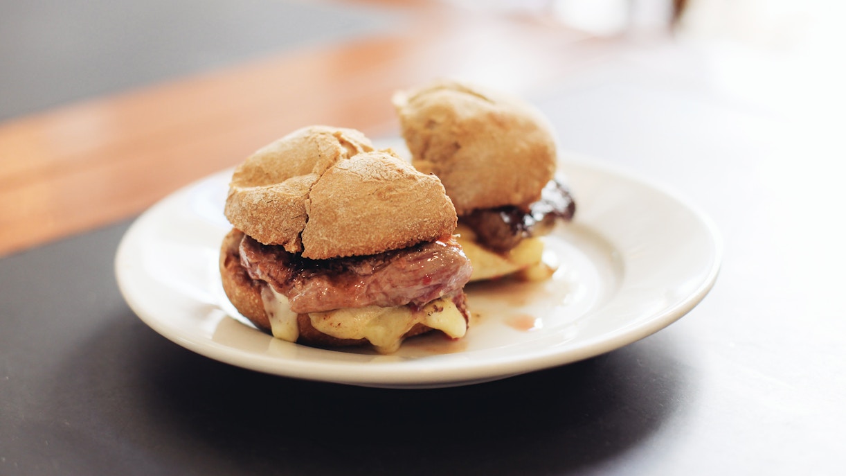 Prego sandwich with steak and mountain cheese on a plate.