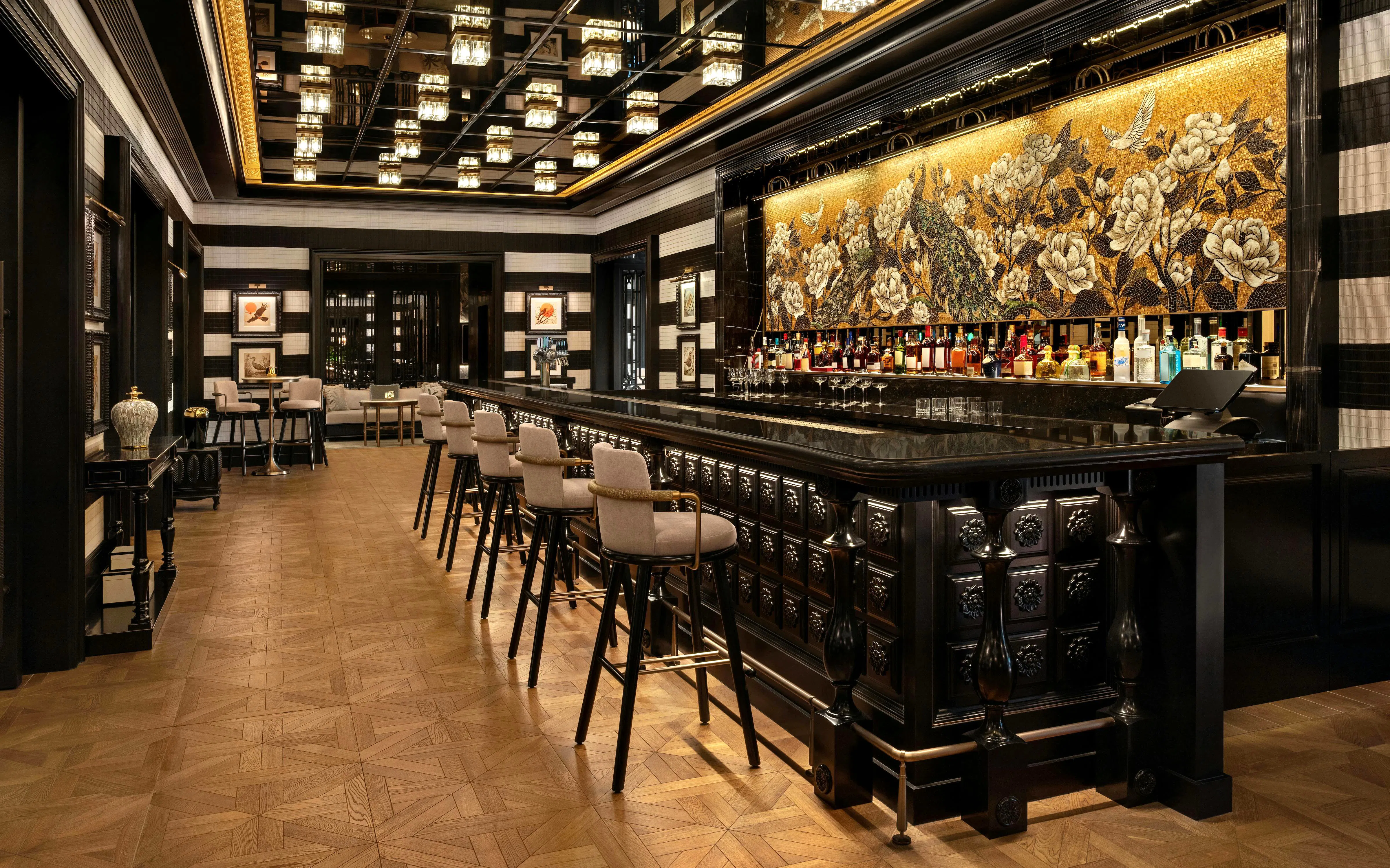 Upscale bar interior with dark wood paneling and black marble counter at Resorts World Sentosa Singapore.