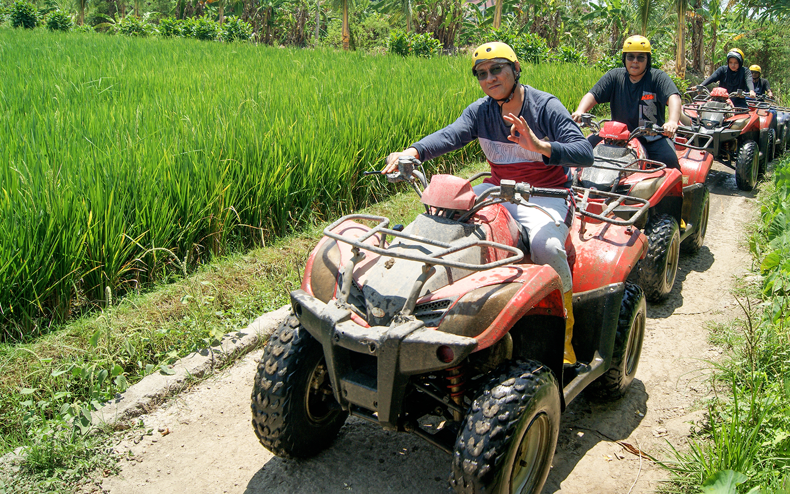 ATV riders on a guided tour through Bali rice fields.
