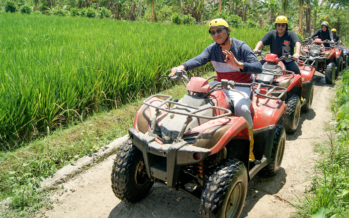 ATV riders on a guided tour through Bali rice fields.