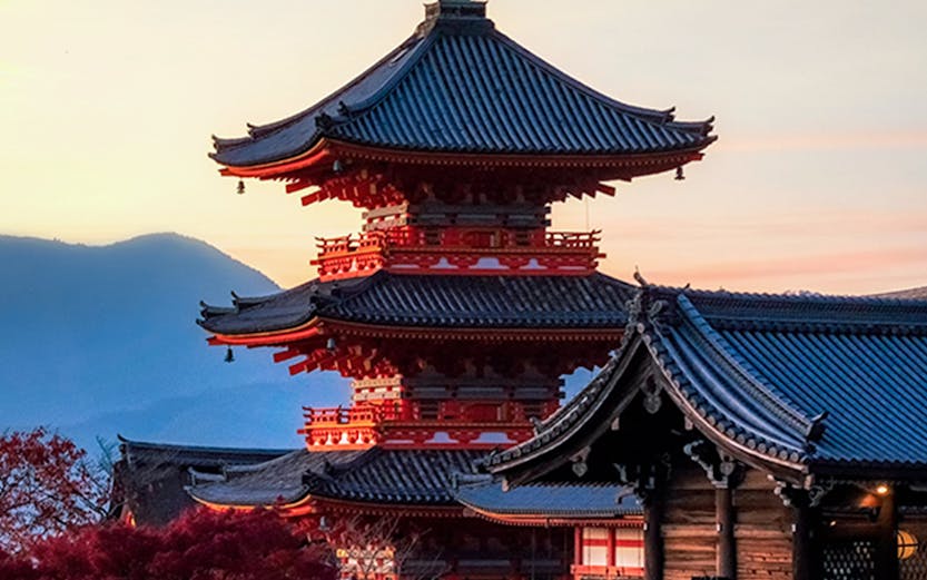 Pagoda at Kiyomizu-dera Temple in Kyoto, Japan, during sunset with autumn foliage.