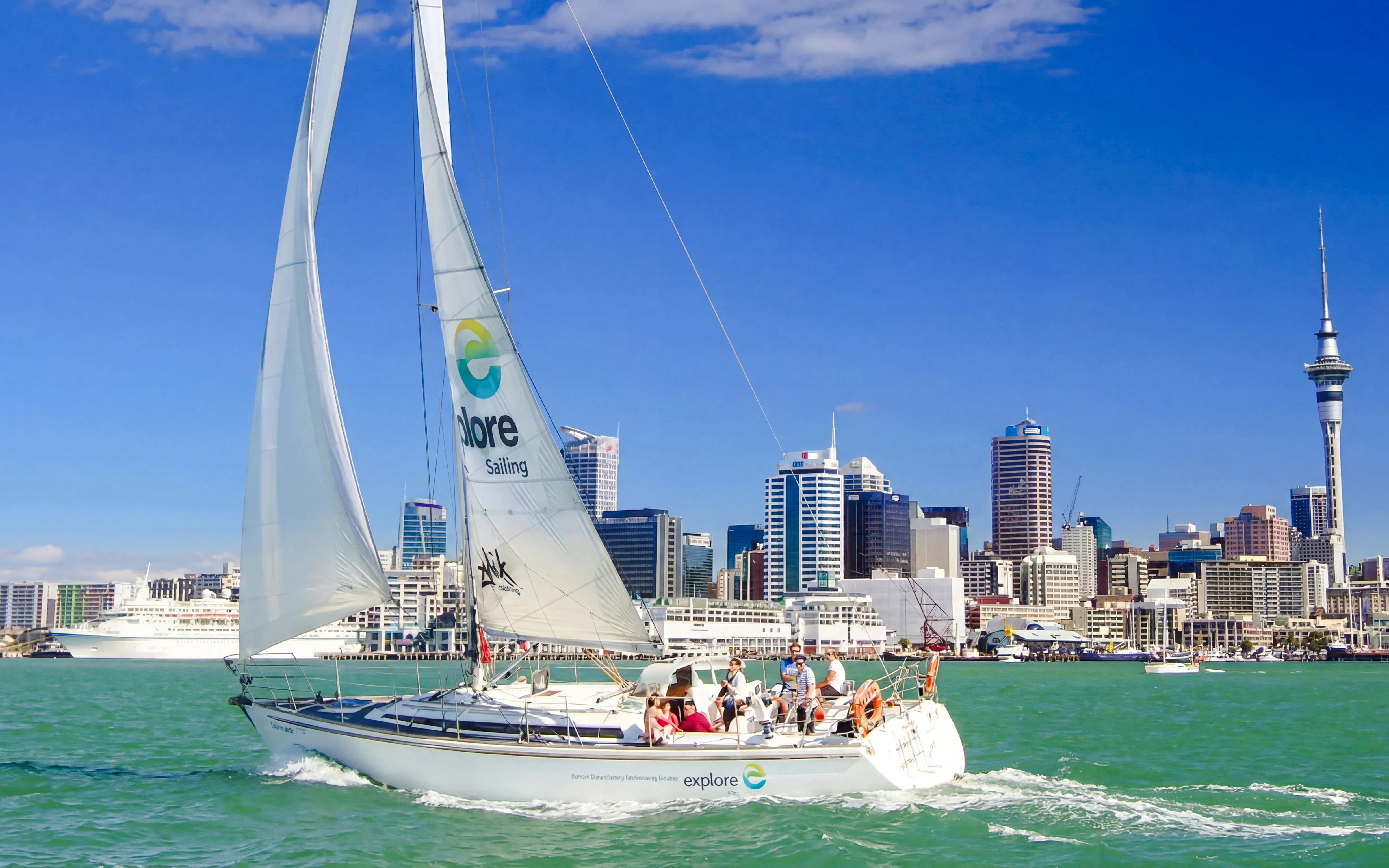 Sailing cruise on Waitematā Harbour with Auckland skyline in the background.