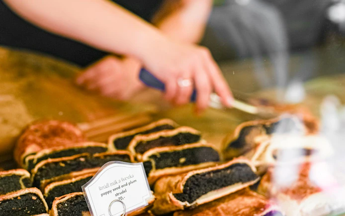 Poppy seed and plum strudel being sliced during Prague food tour.