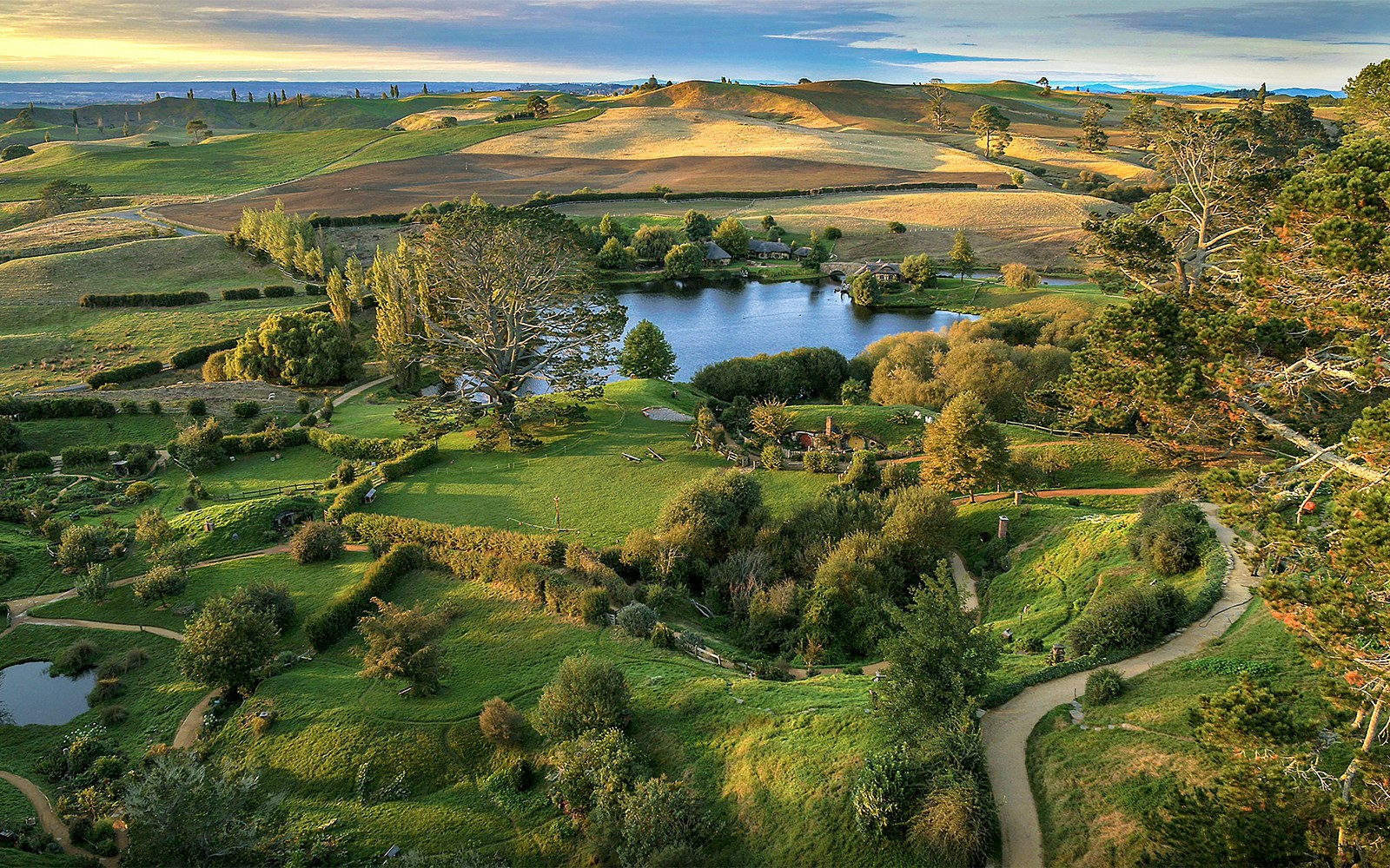 Hobbiton Movie Set landscape with lush greenery and winding paths, seen on Auckland private tour.