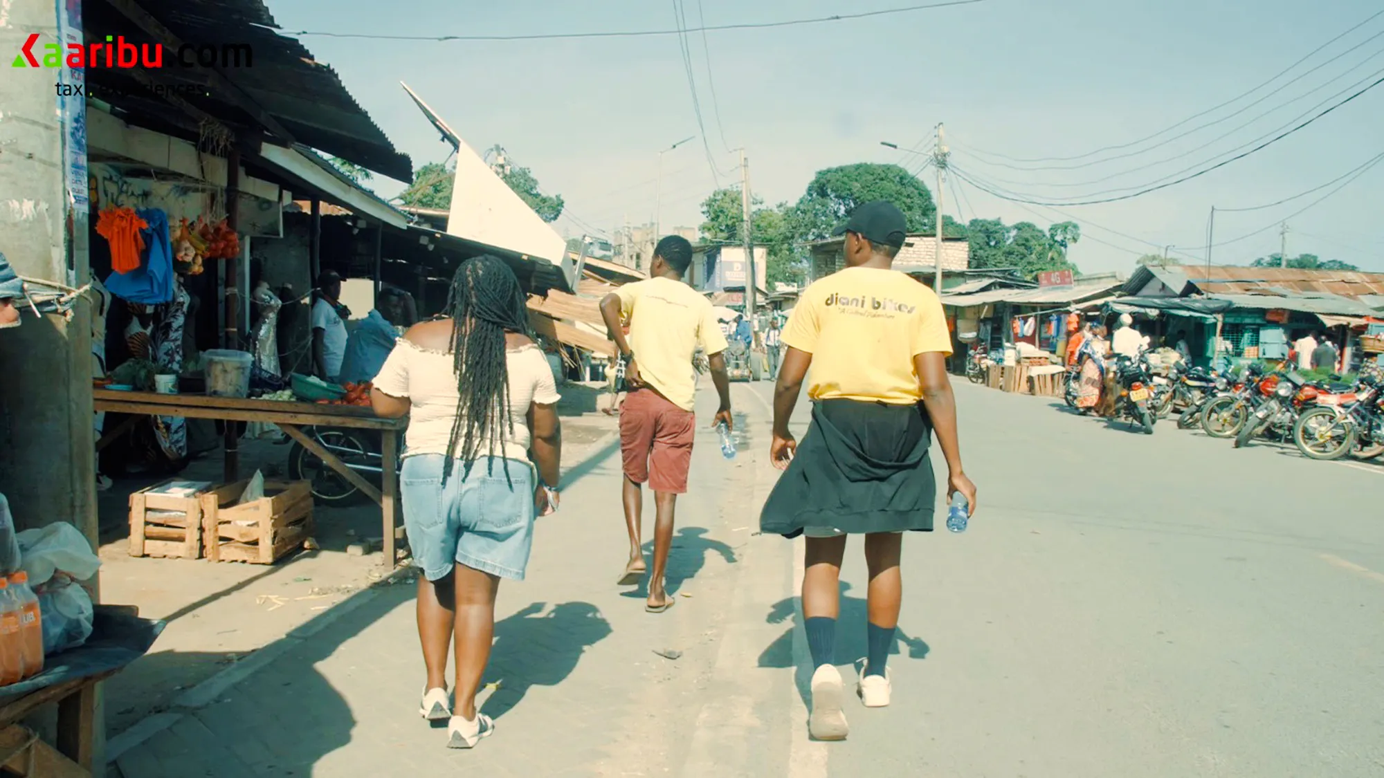 Tourists walking through a local market during a village bike tour in Diani Beach.