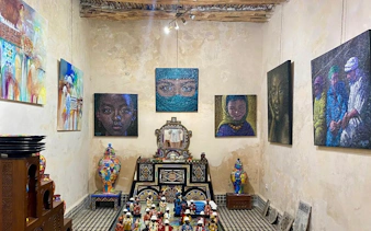 Essaouira art gallery with colorful paintings and traditional Moroccan pottery on display.
