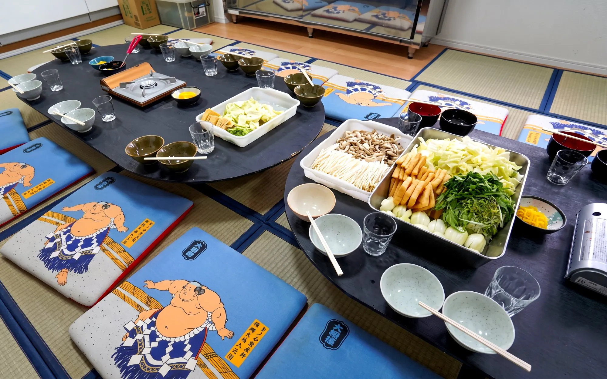 Tatami room with sumo-themed cushions and traditional Japanese meal setup in Tokyo.