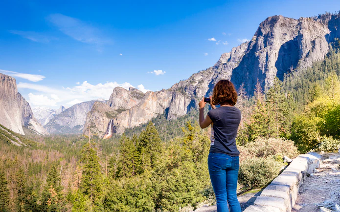 Young woman photographing Yosemite Valley from Tunnel View, Yosemite National Park, USA.