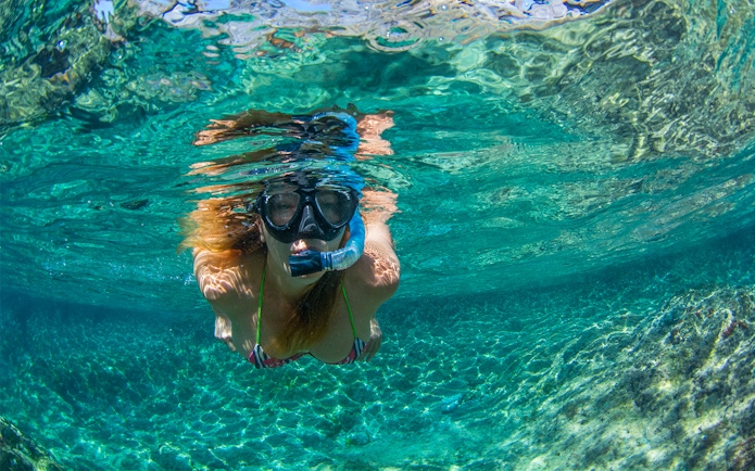 Snorkeler exploring clear waters near Tavolara Island.
