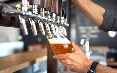 Pouring draft beer at a cafe from a row of taps.