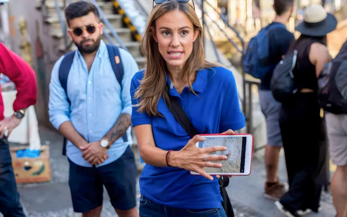 Tour guide showing map to tourists near Duomo Milan Cathedral.