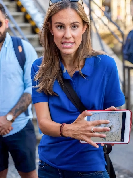 Tour guide showing map to tourists near Duomo Milan Cathedral.