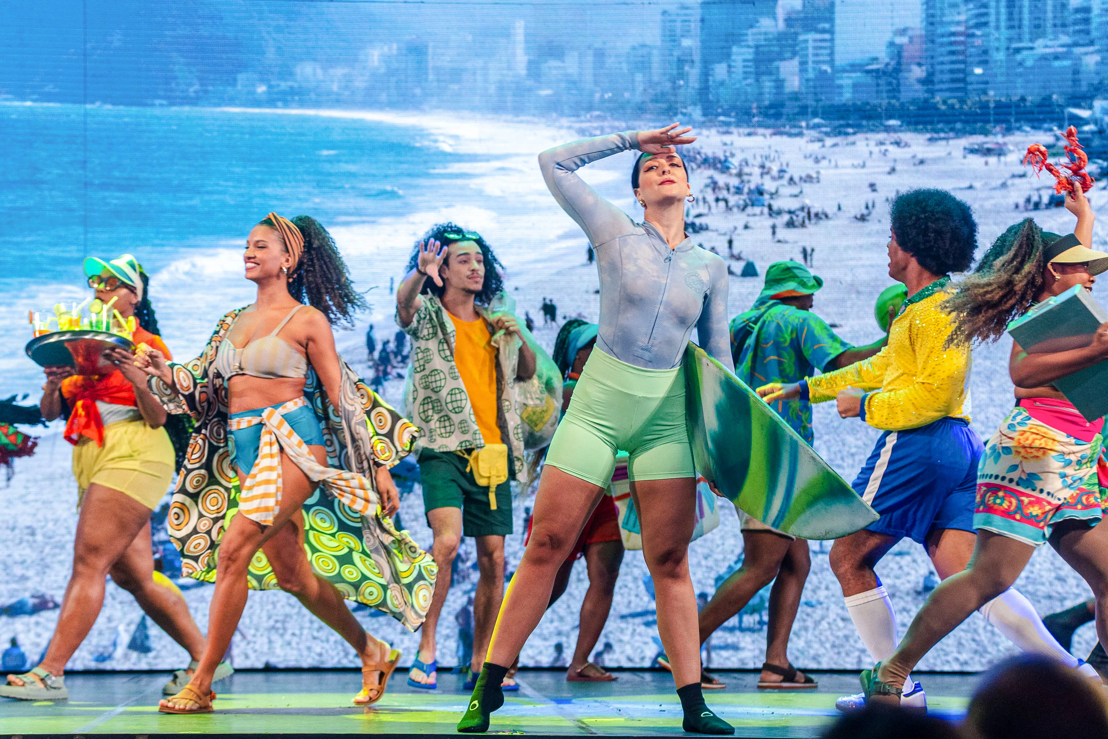 Performers dancing in colorful costumes at Rio Scenarium, Rio de Janeiro, with a beach backdrop.