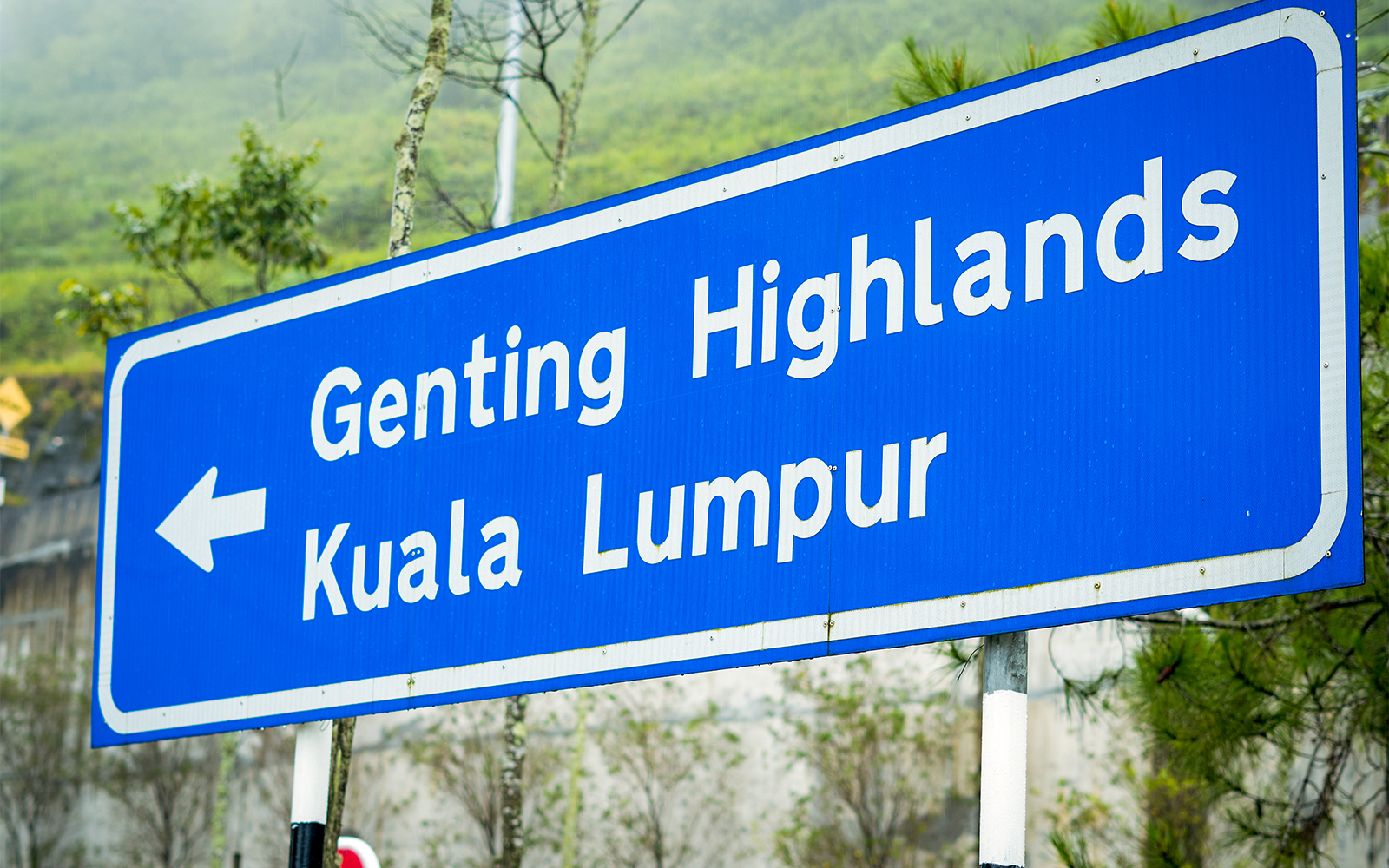 Road sign pointing to Genting Highlands and Kuala Lumpur.