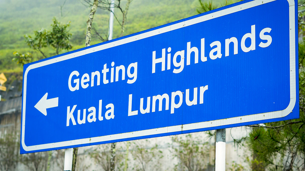 Road sign pointing to Genting Highlands and Kuala Lumpur.