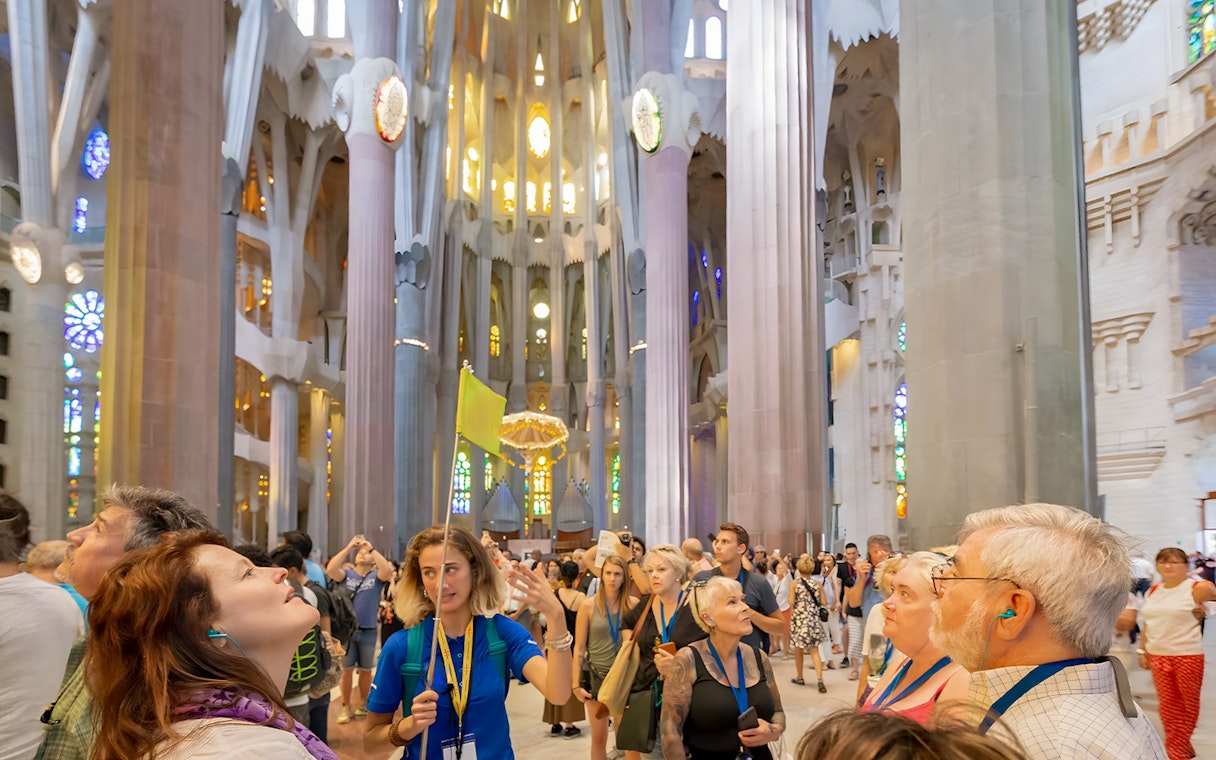 Guide leading tourists inside Sagrada Familia, Barcelona.