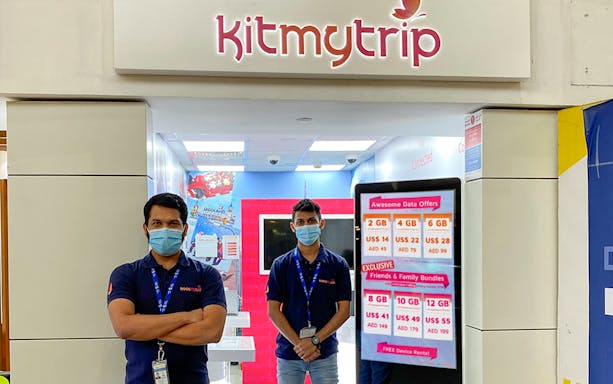 4G Pocket WiFi rental counter at airport with staff and data offers displayed.