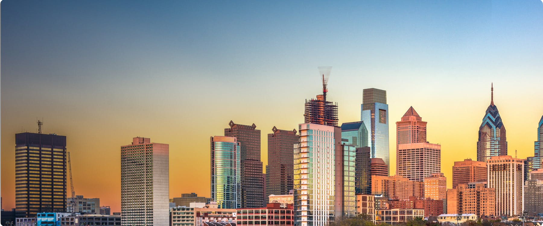 Philadelphia skyline at sunset with modern skyscrapers.