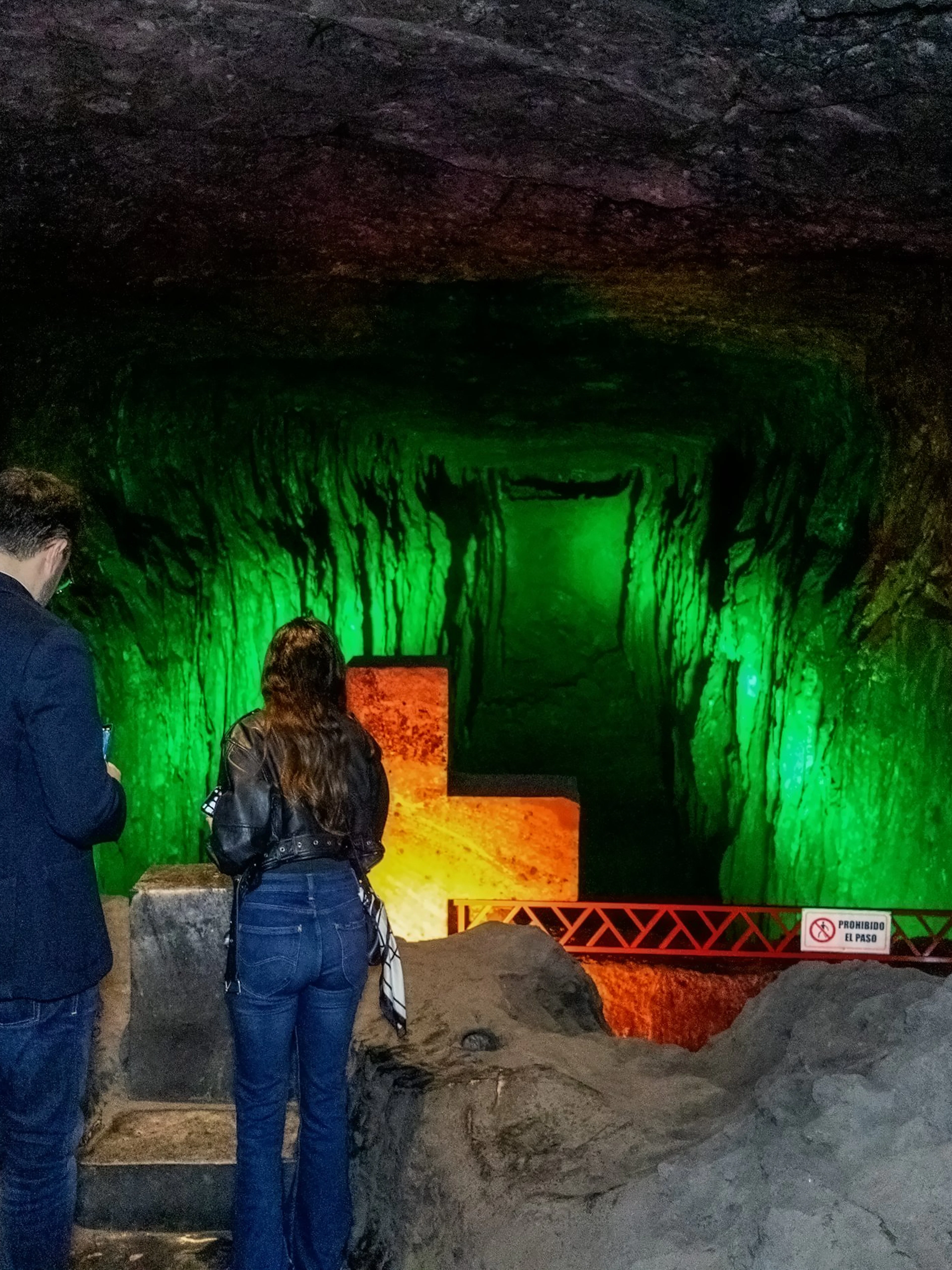 Visitors exploring illuminated tunnel at Zipaquira Salt Cathedral, Colombia.
