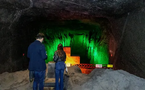 Visitors exploring illuminated tunnel at Zipaquira Salt Cathedral, Colombia.