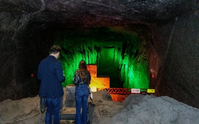 Visitors exploring illuminated tunnel at Zipaquira Salt Cathedral, Colombia.