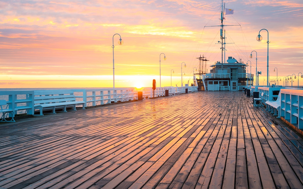 Sunset view from Sopot Pier with a ship docked, highlighting the cruise experience.