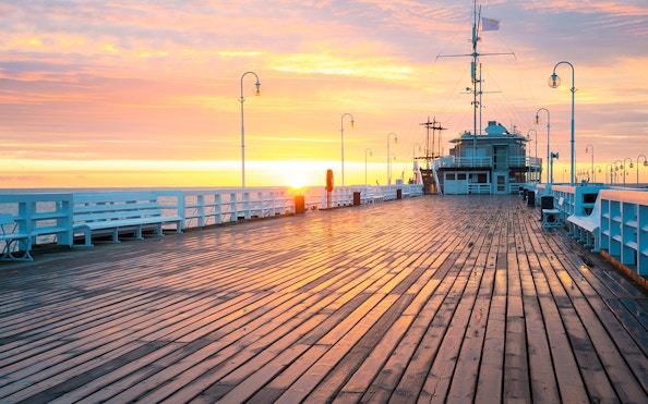 Sunset view from Sopot Pier with a ship docked, highlighting the cruise experience.