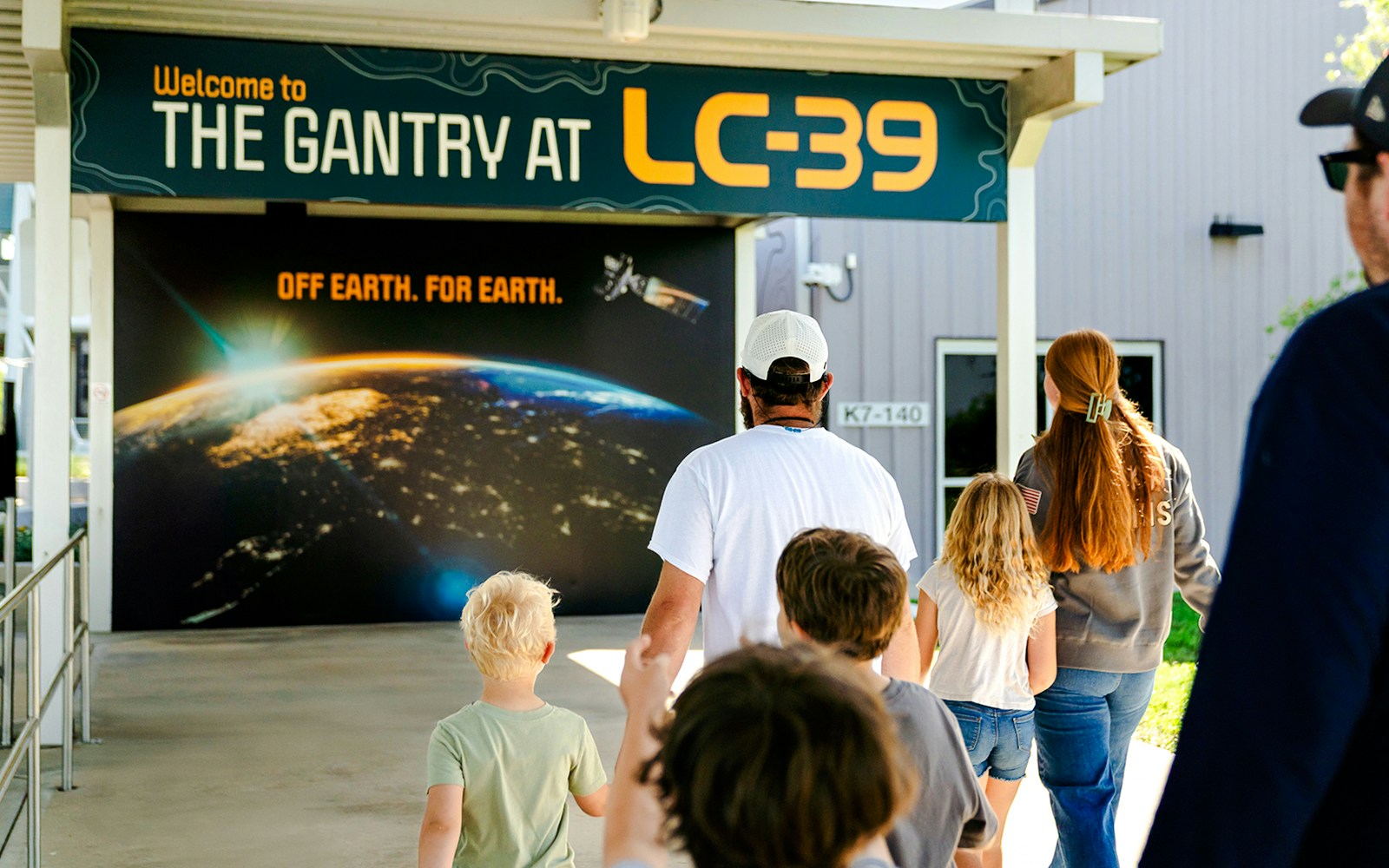 Family entering the Gantry at LC-39, space-themed entrance in view.